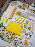 Collection of stationery items including notebooks, pens, and decorative elements on a white surface.